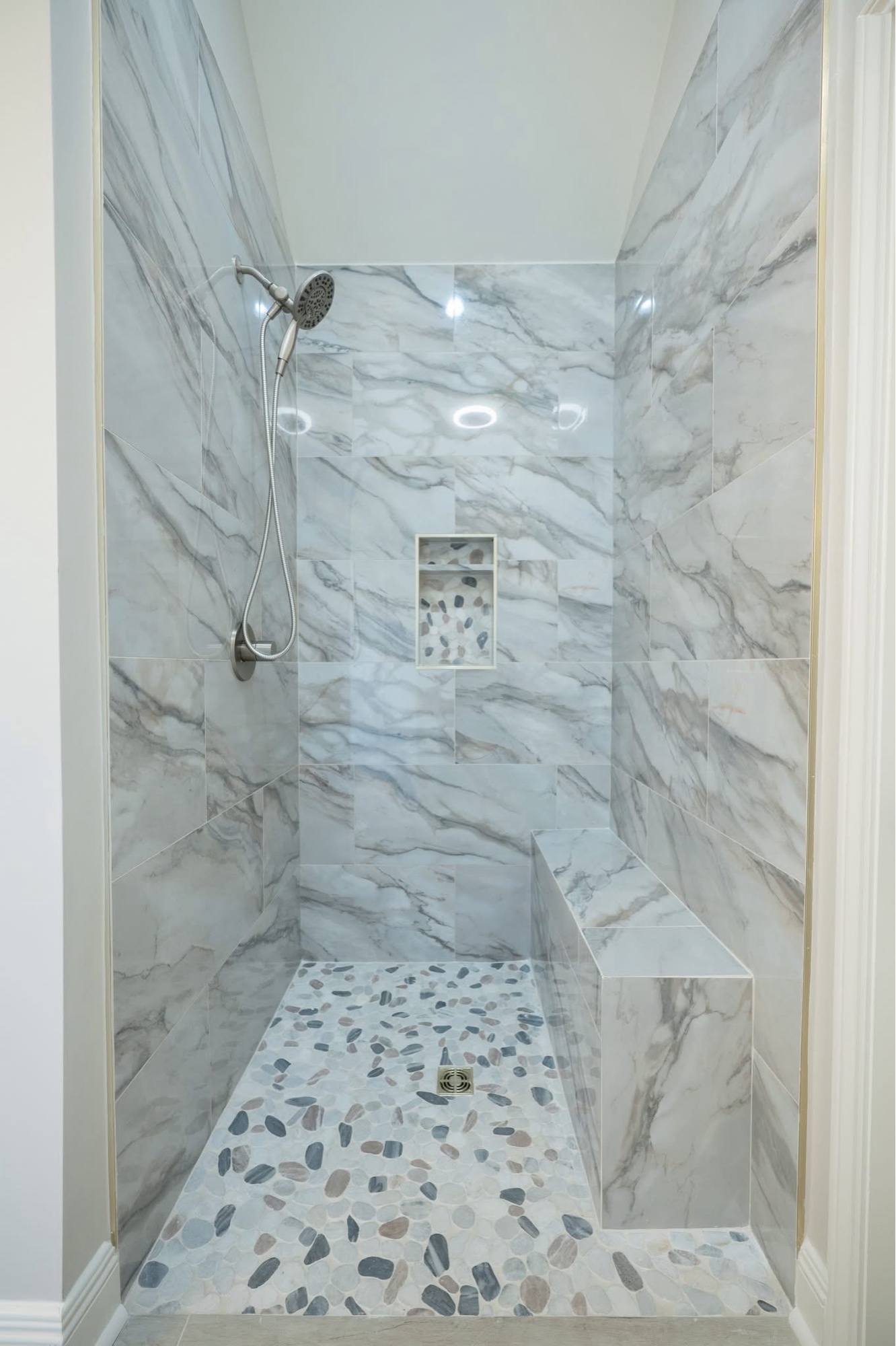Shower after — marble walls with pebble floor