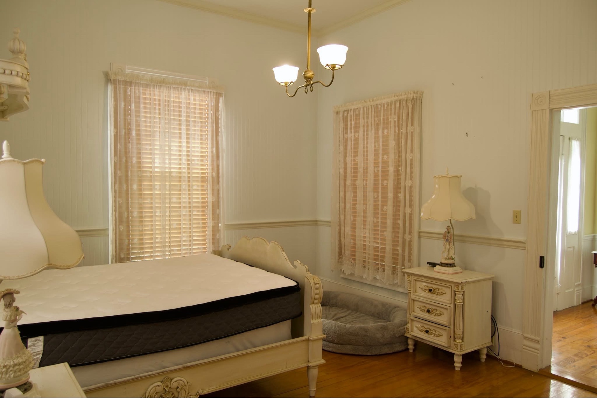 Bedroom before — dated historic room with lace curtains