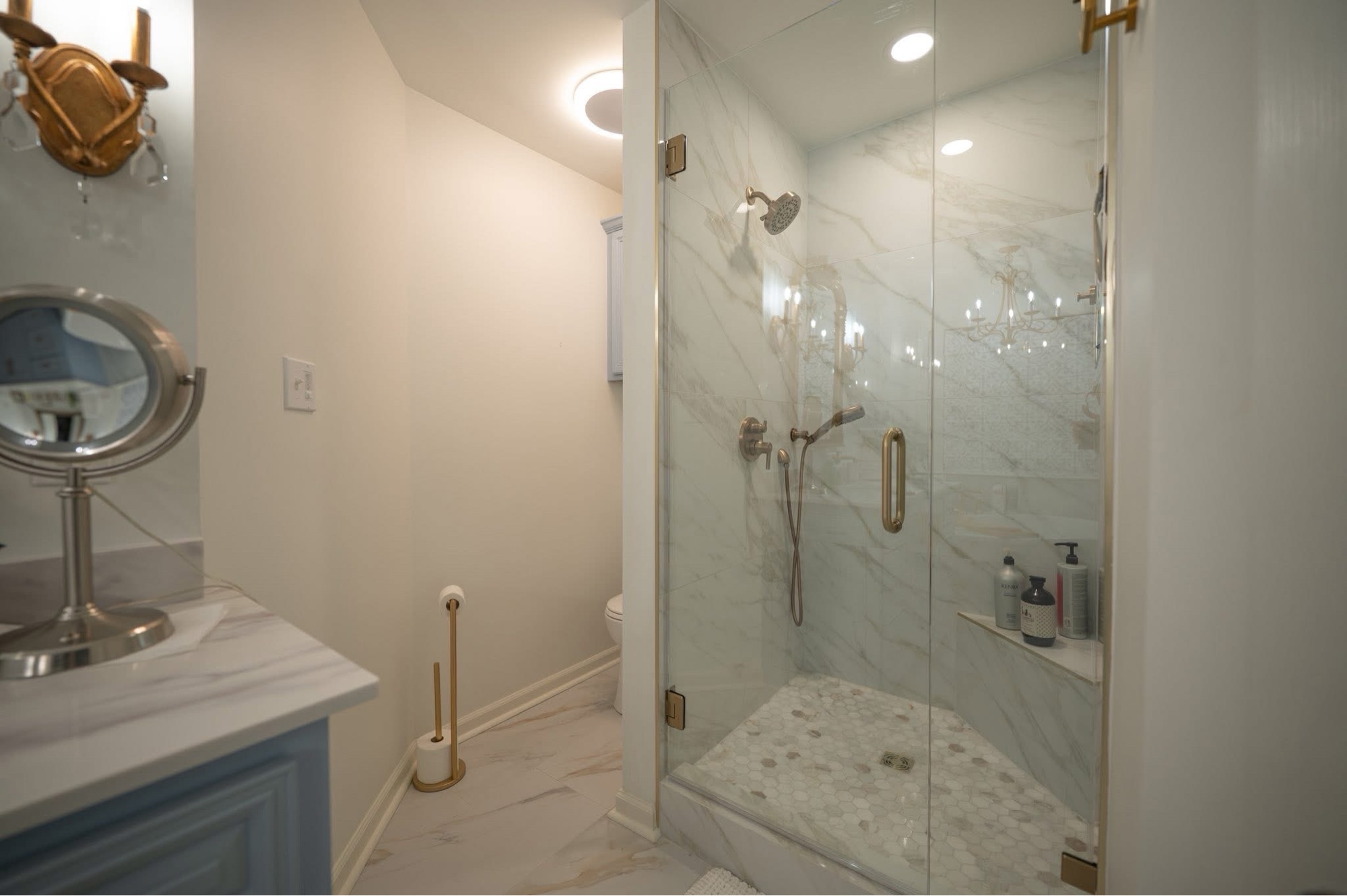 Guest bath after — marble and brass with blue vanity