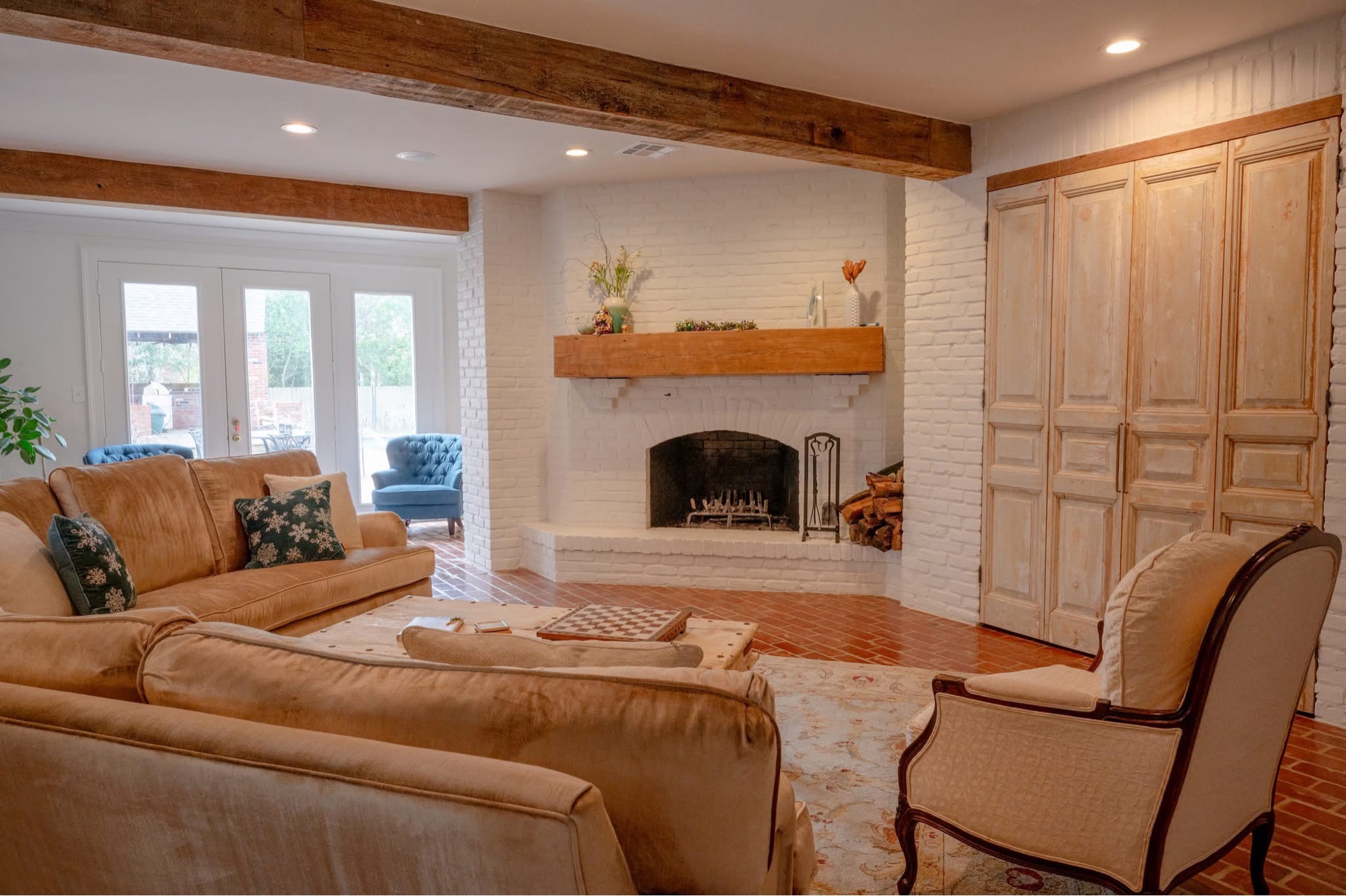 Living room after — whitewashed brick fireplace and exposed beams