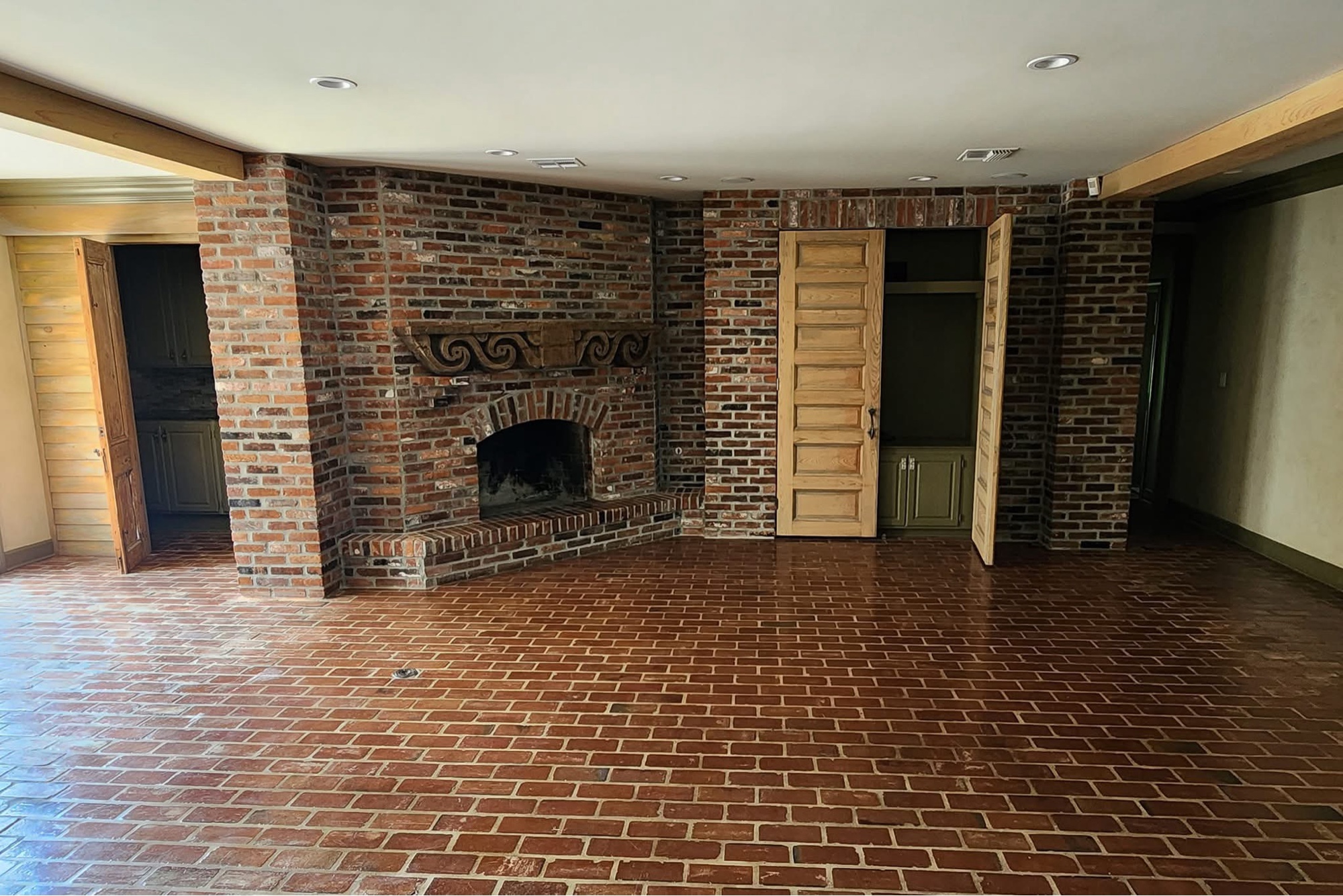 Living room before — dark red brick fireplace wall