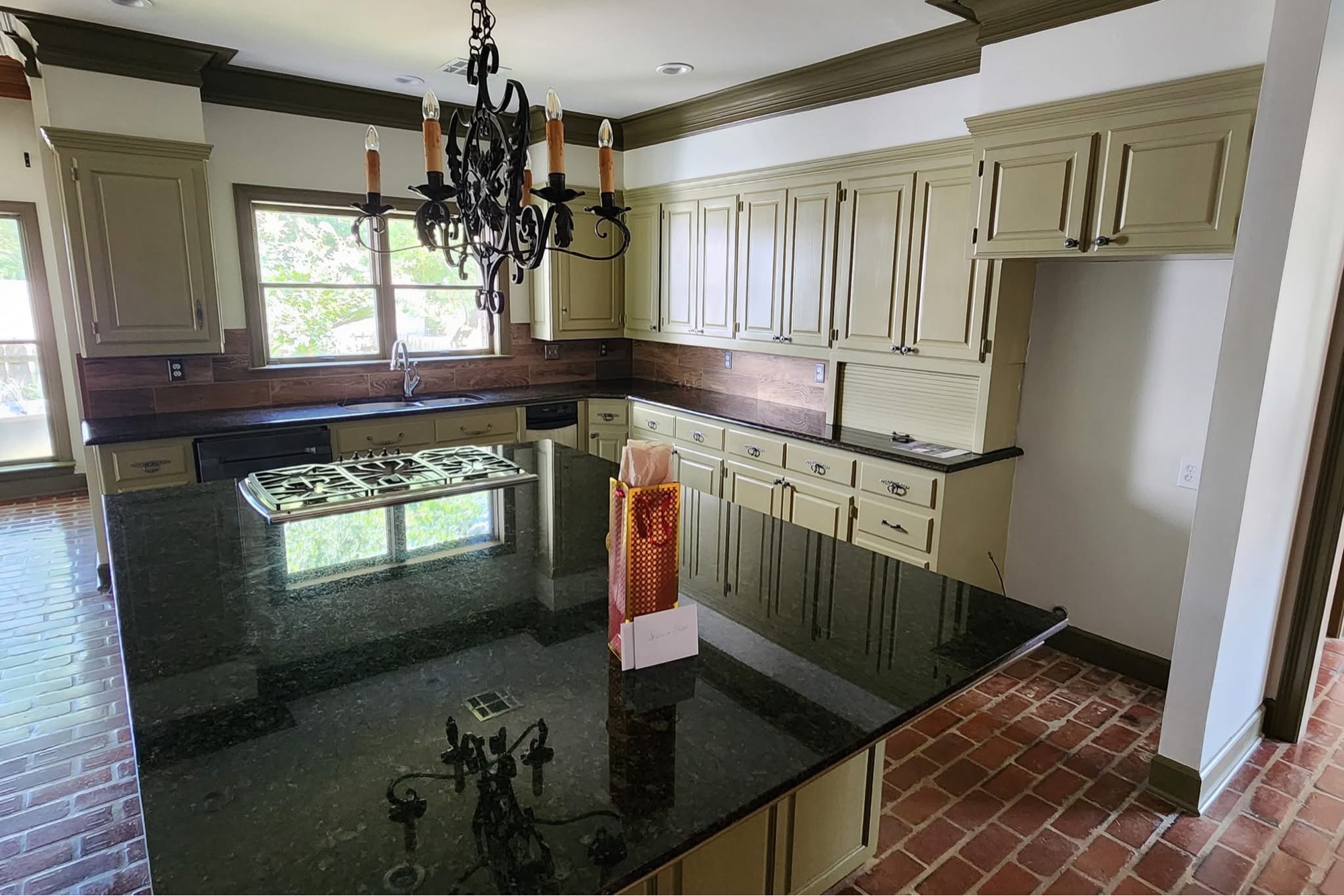 Kitchen before — olive cabinets and black granite