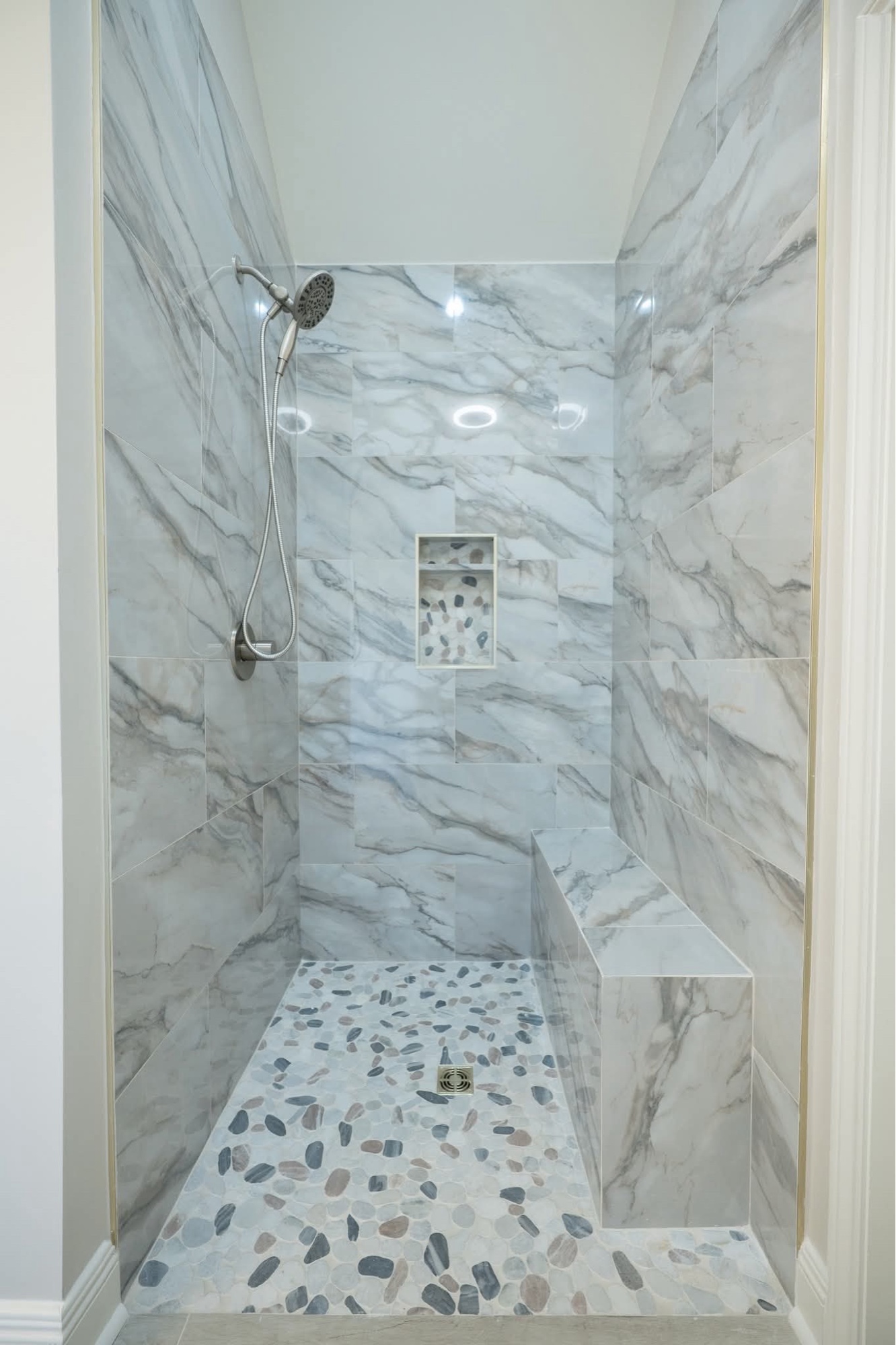 Marble walk-in shower with brass fixtures