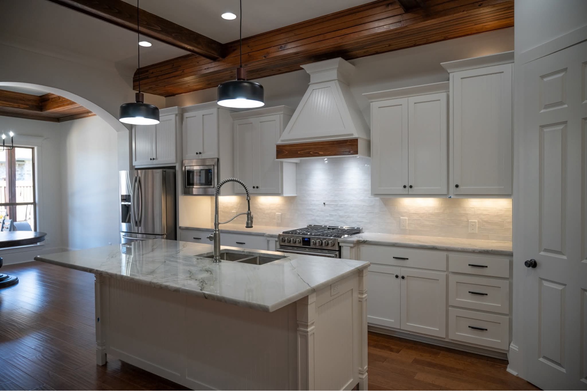 White kitchen with wood ceiling beams